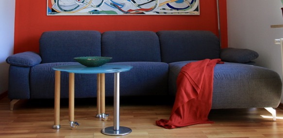 Sofa grau vor roter Wand